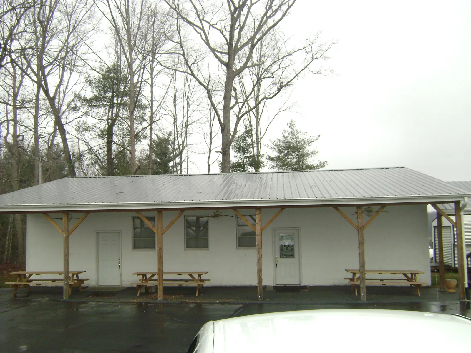 Gray metal roof over a block building with a timber post porch in Princeton